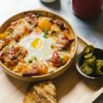 Fotos von Kartoffeln und Wurst angebraten und mit einem Spiegelei im Backofen überbacken. Dazu gibt es Brot und Jalapenos.